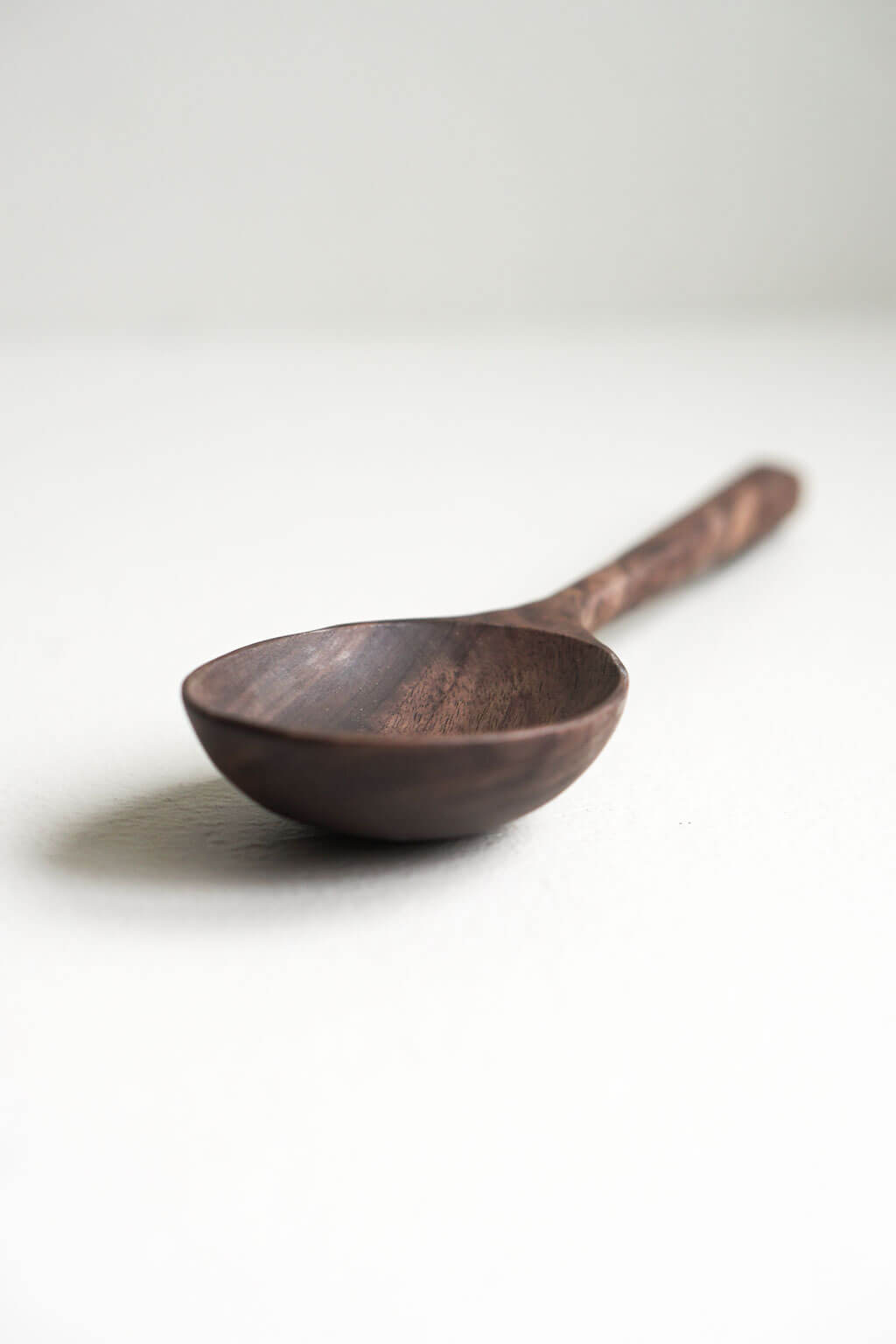 Hand-carved walnut wooden spoon with deep rounded bowl and smooth natural finish