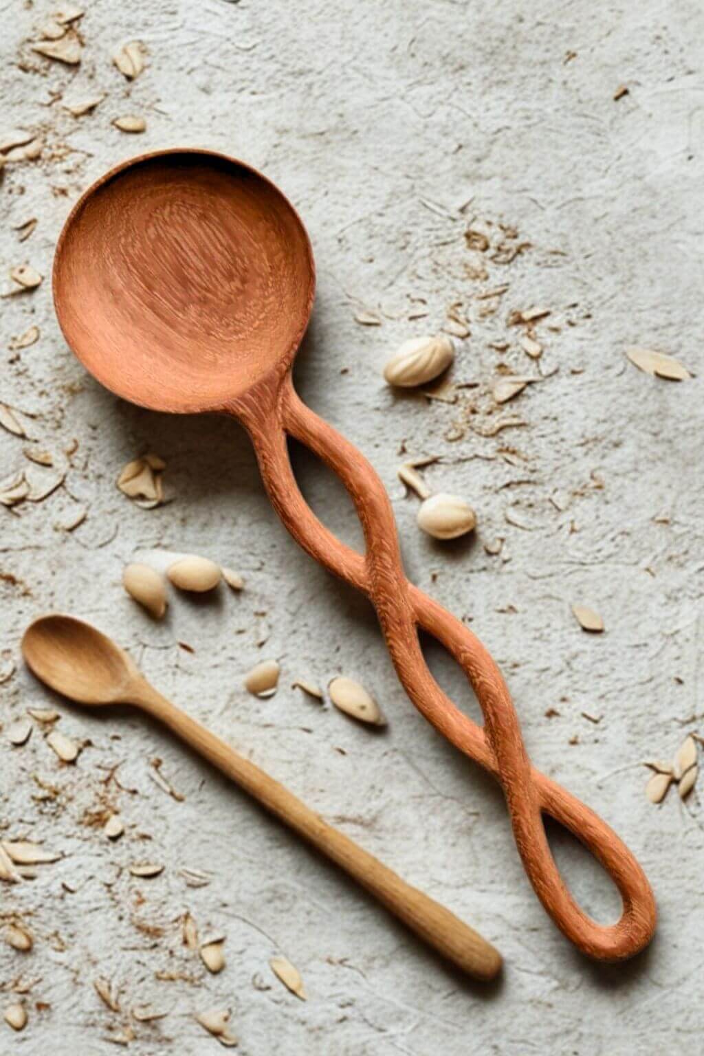 Twisted Handle Doussie Wooden Spoon on a surface with seeds and grains