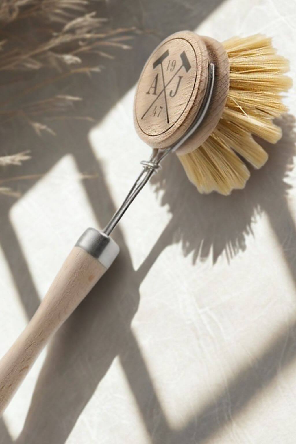 Dish brush with wooden handle and bristles on a light background
