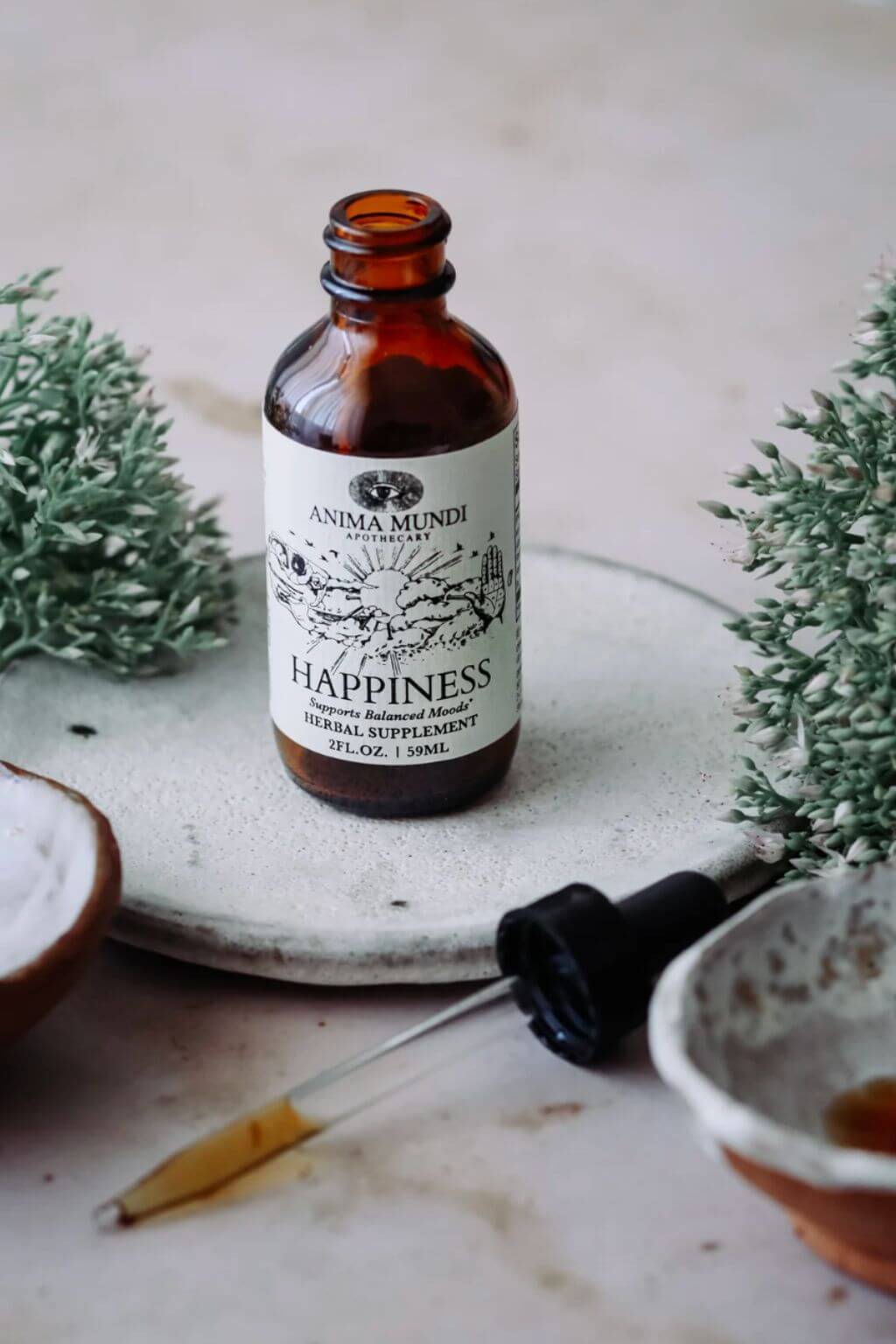 Amber glass bottle labeled 'Happiness' with a dropper on a textured surface