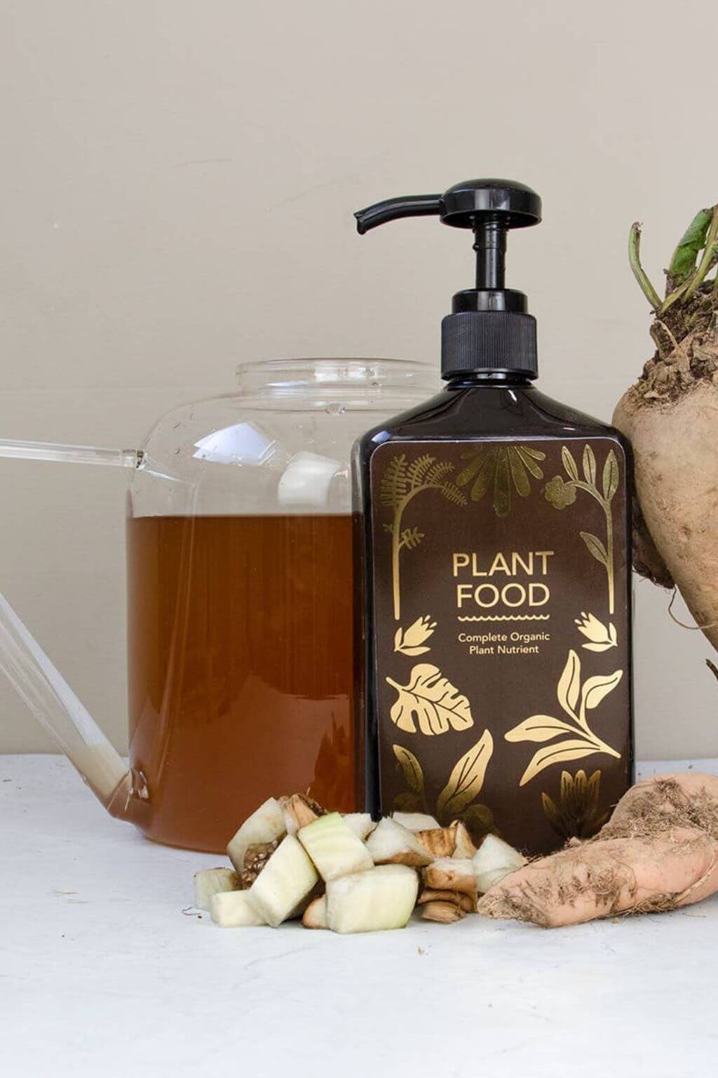 Organic plant food bottle next to watering pitcher