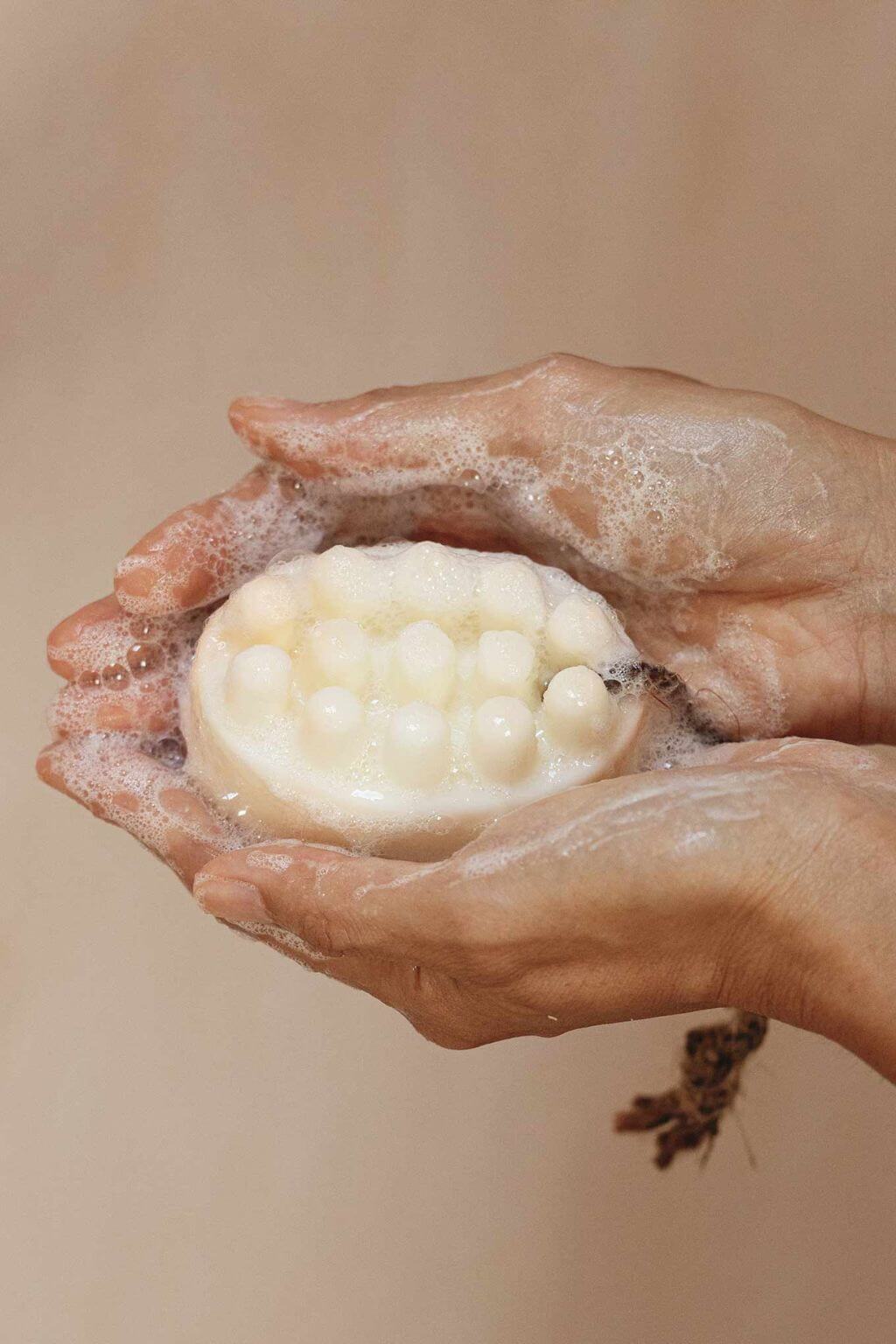hinoki shea butter bath ritual soap bar with massage nodes in hands