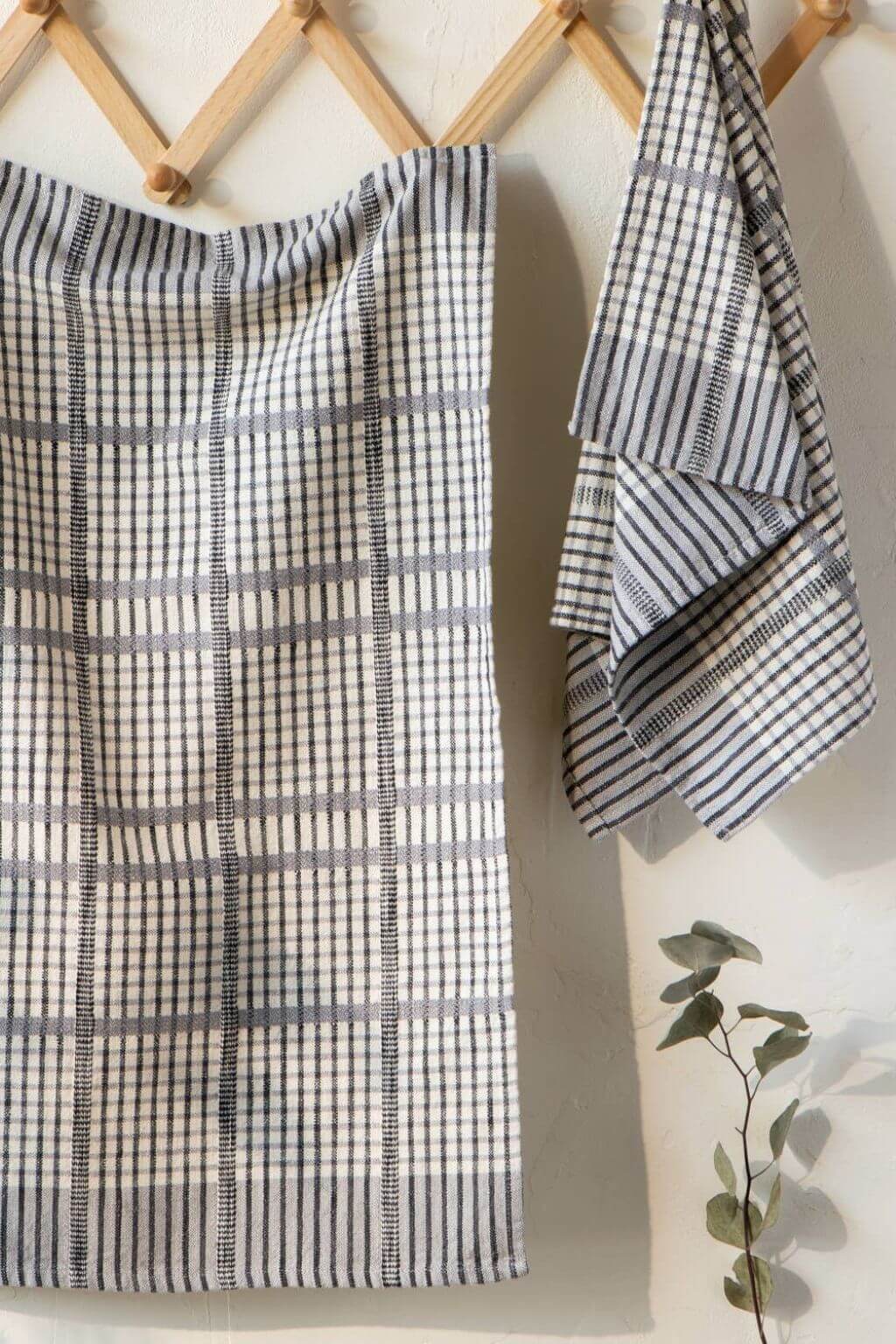 pewter check cotton dish towels hanging on wooden wall rack