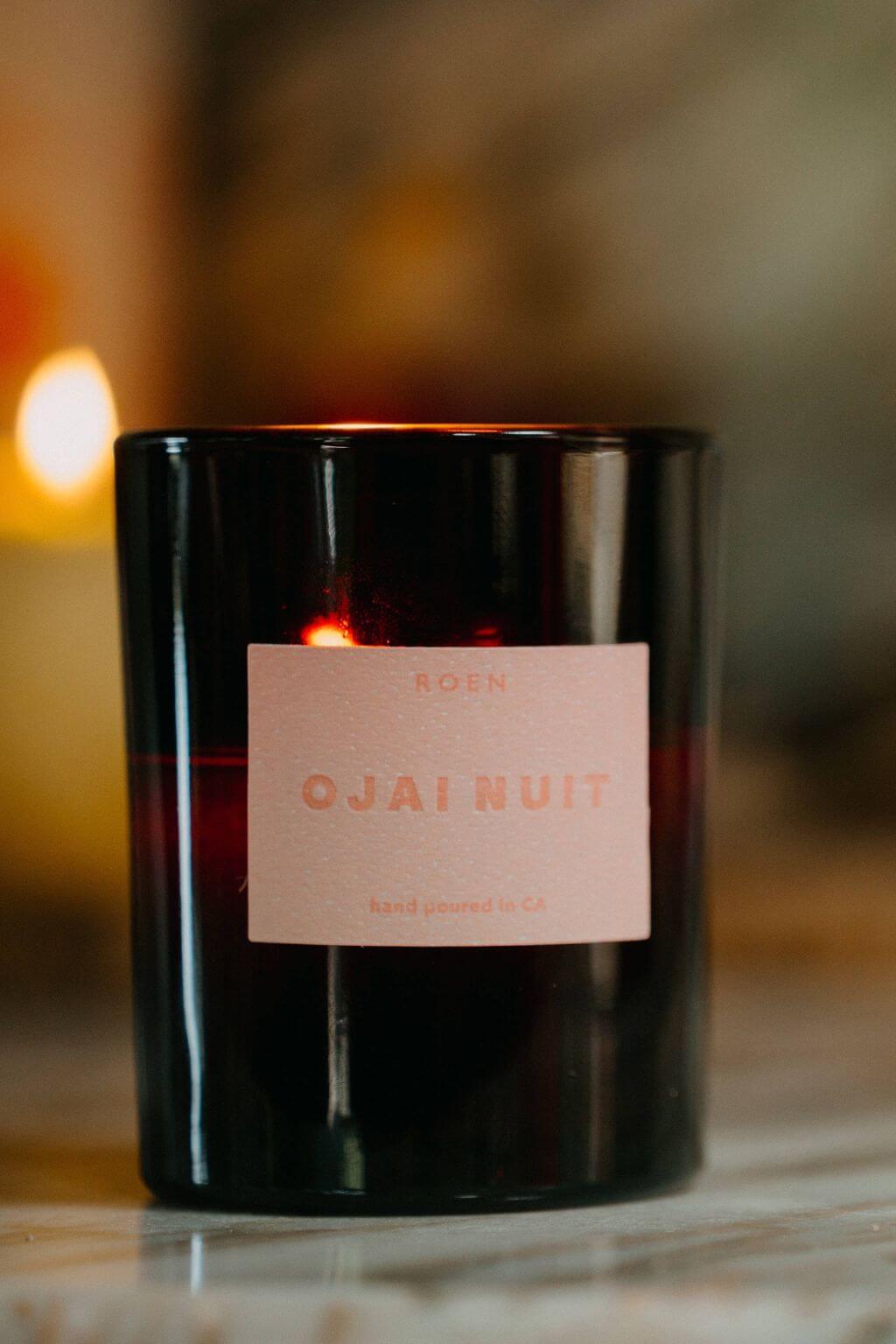 Close-up of lit Ojai Nuit candle in amber glass