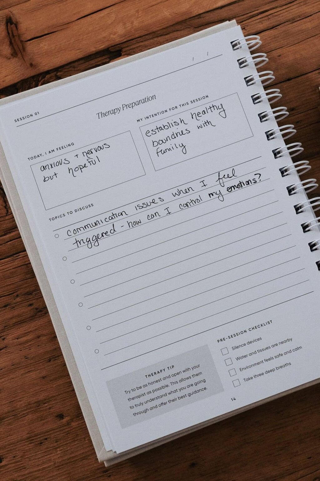 Notebook with therapy preparation worksheet on a wooden surface