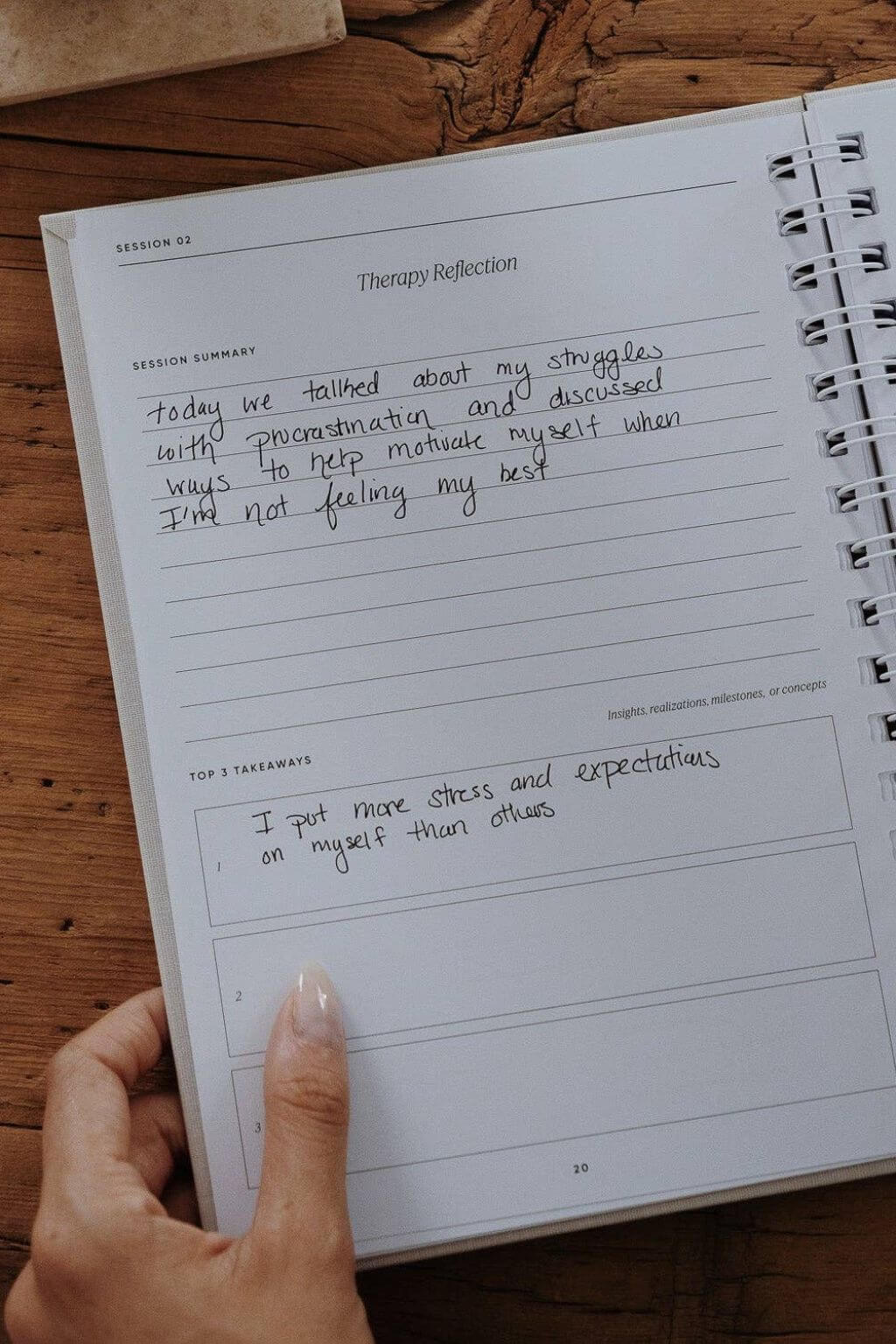 Notebook with therapy reflection entries on a wooden surface