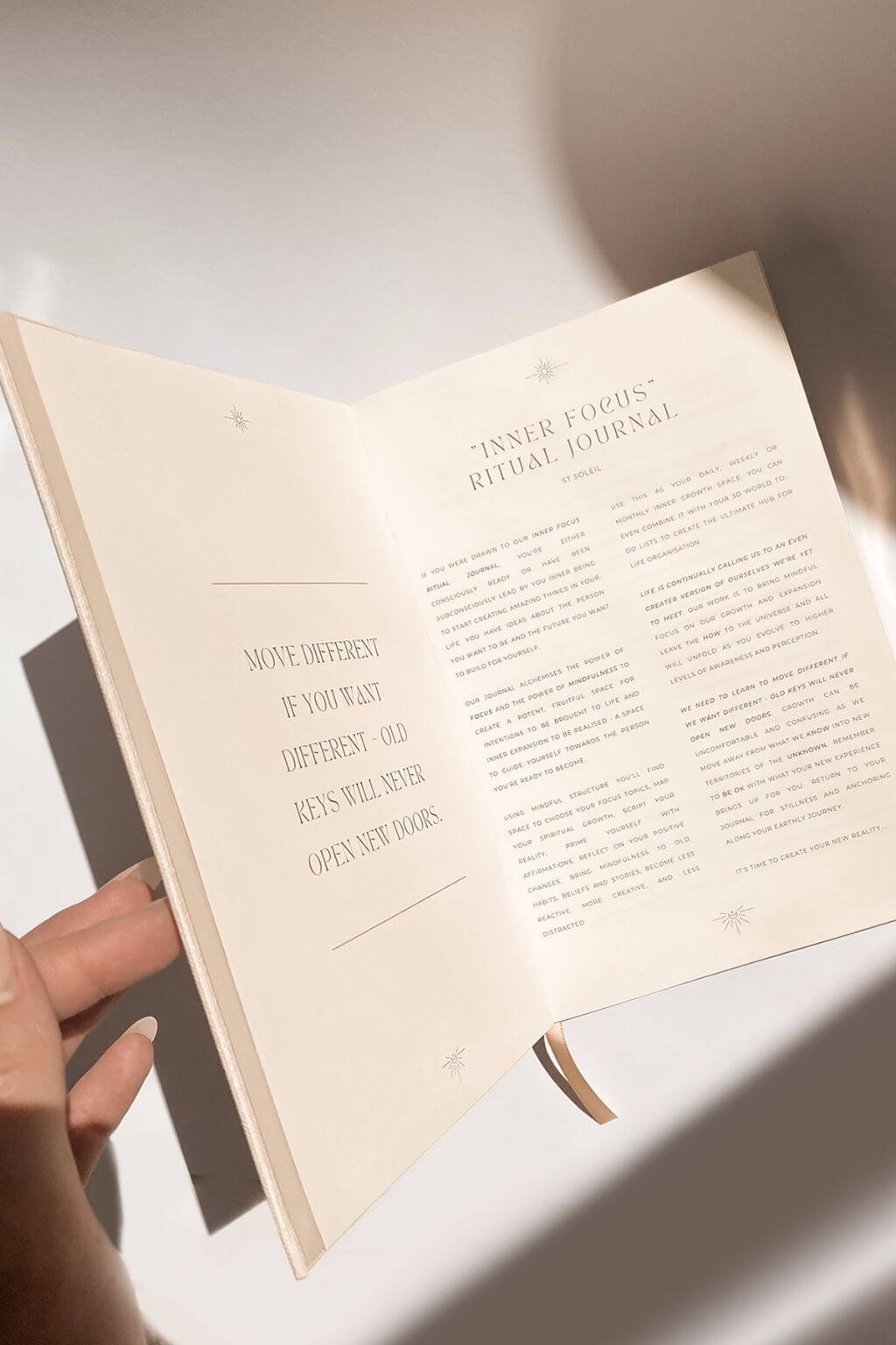 Open book with text held by a hand on a light background
