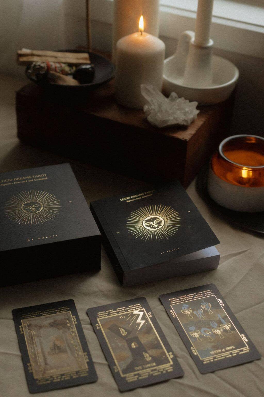 Black Lucid Dream tarot card deck with gold designs on a table with candles and crystals.
