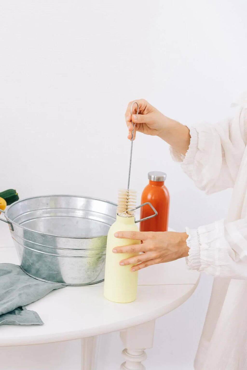Long-handled bottle brush in use, designed to reach deep and clean reusable bottles with ease