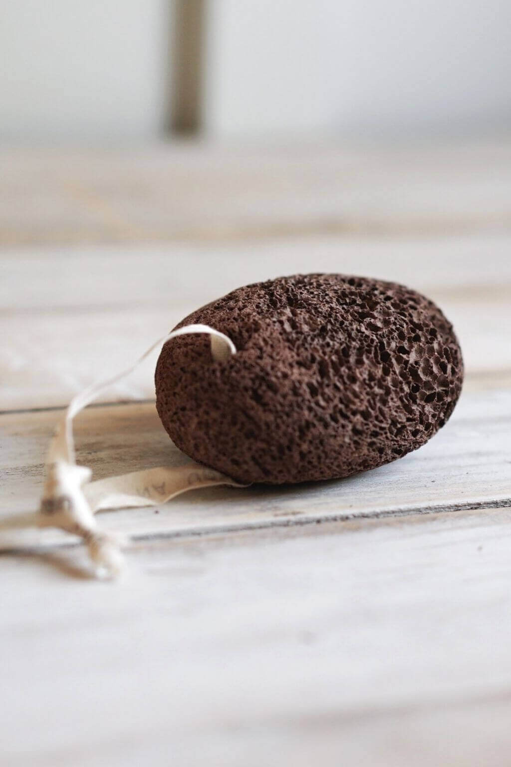 Natural exfoliating pumice stone crafted from volcanic lava with cotton hanging loop for everyday foot care