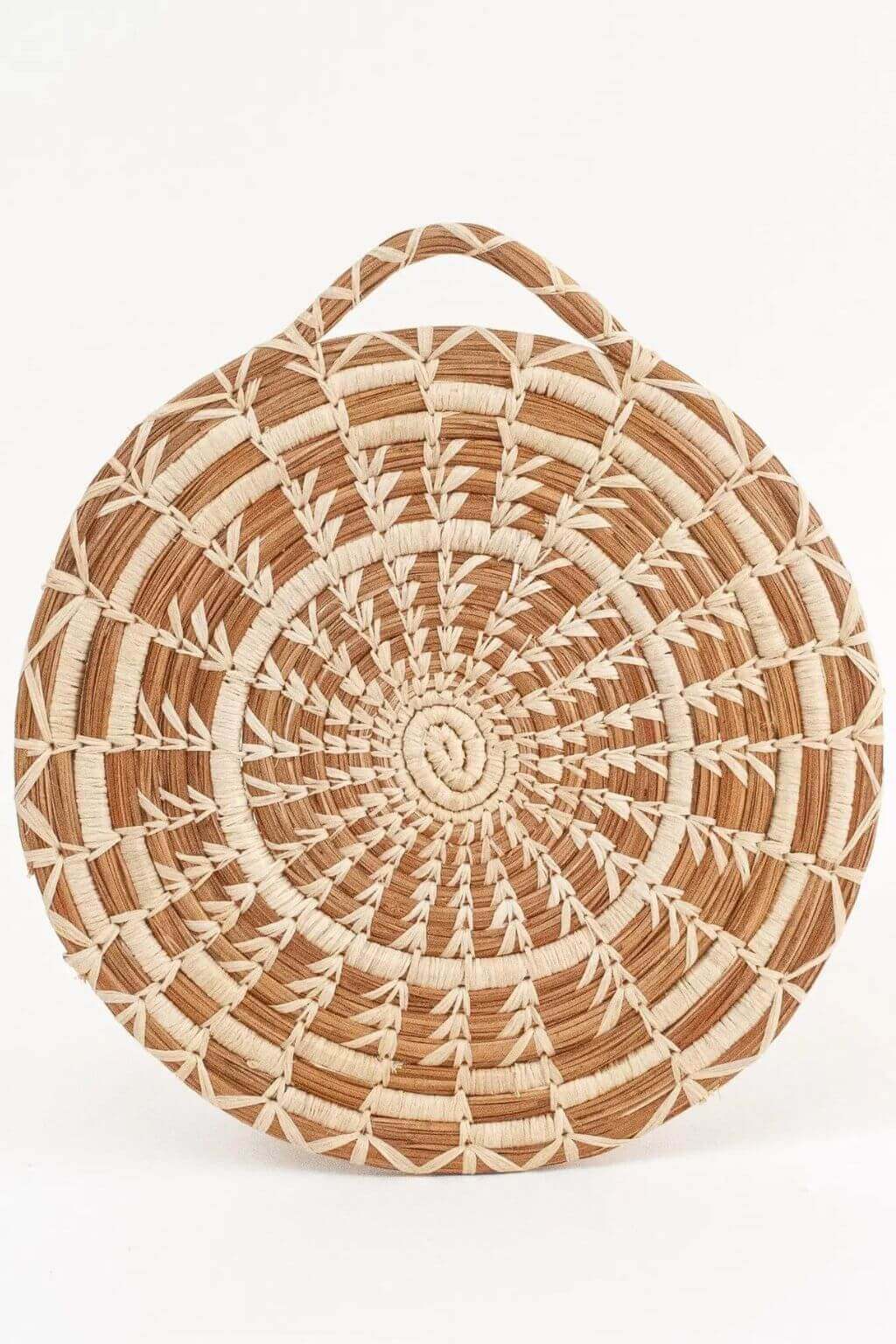 Round woven basket with a handle on a white background