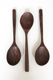 Set of three hand-carved walnut wooden spoons with varied bowl shapes and natural wood grain