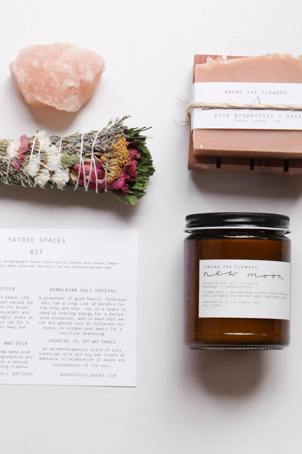 Sacred self-care kit with amber candle, floral smudge stick, Himalayan salt crystal, and handmade soap with printed card