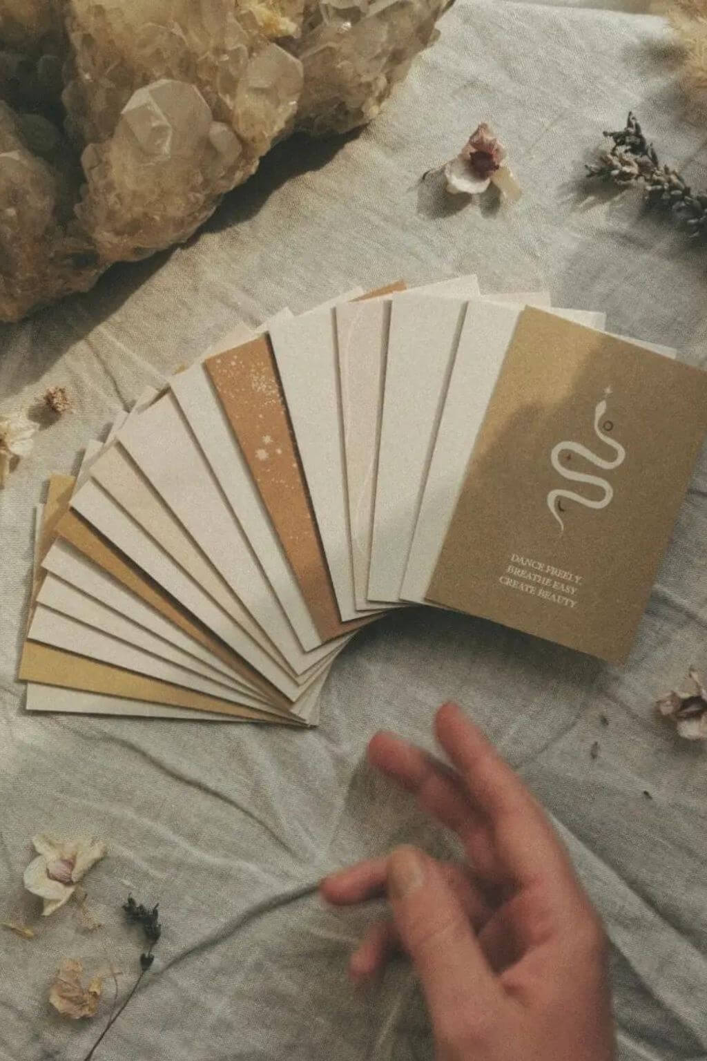 Neutral-toned Trust Your Inner Vision affirmation cards spread across linen beside crystals and dried flowers