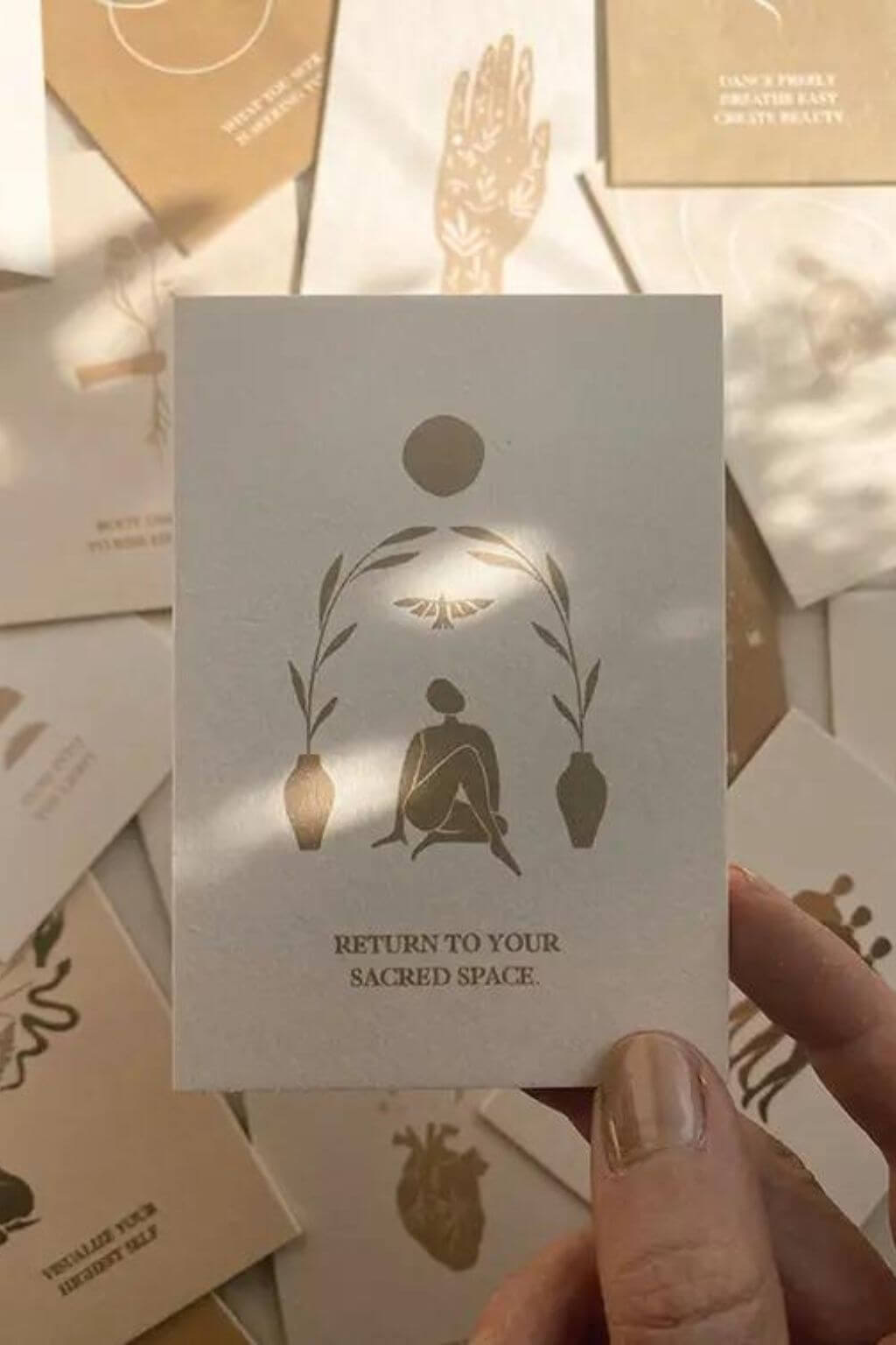Affirmation card on natural cardstock with natural lighting. Card reads "Return to your Sacred Space."