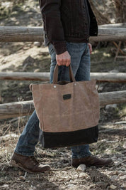 Man seated indoors with oversized waxed canvas tote bag