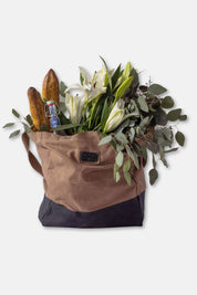 Brown tote bag with flowers, bread, and a bottle on a white background
