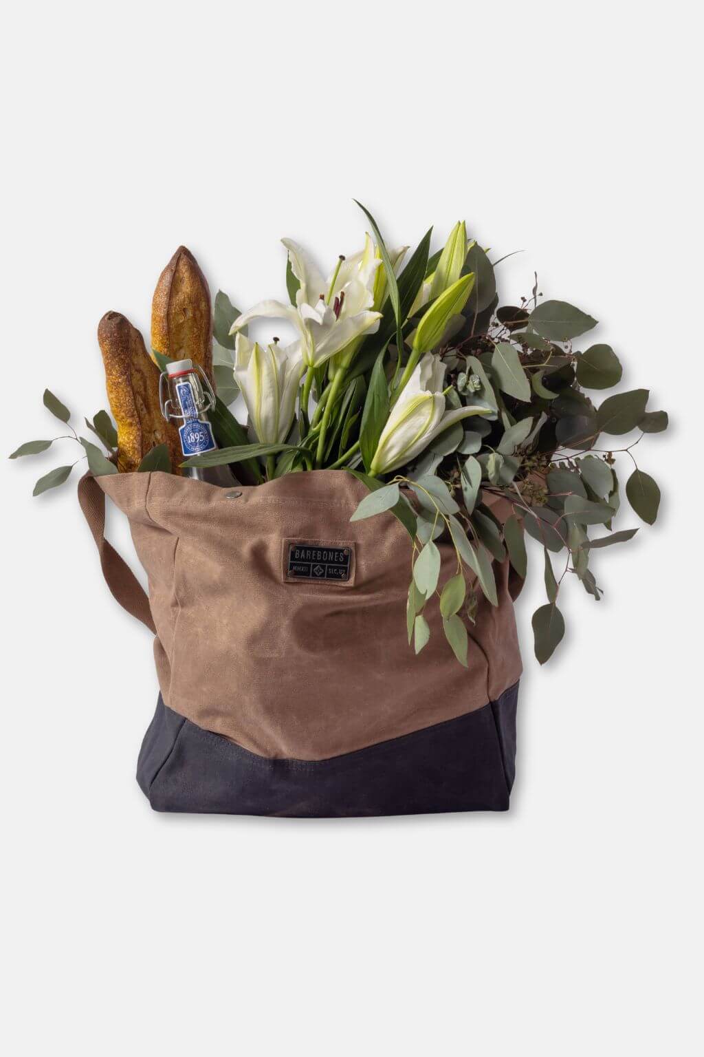 Brown tote bag with flowers, bread, and a bottle on a white background