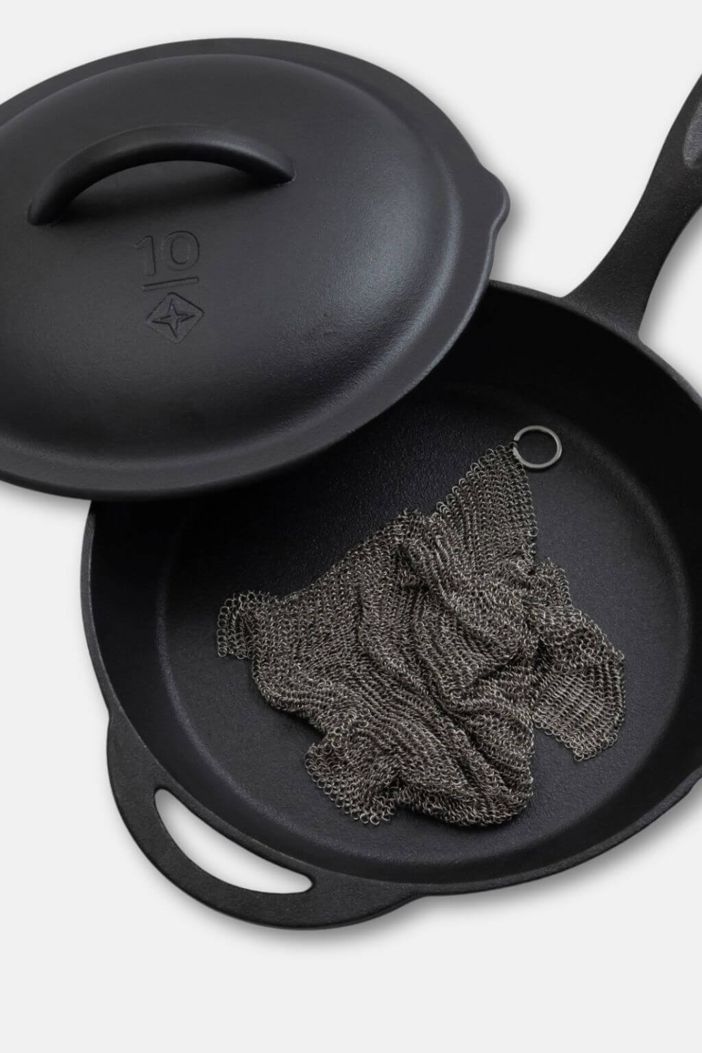Stainless steel cleaning mesh resting inside cast iron skillet