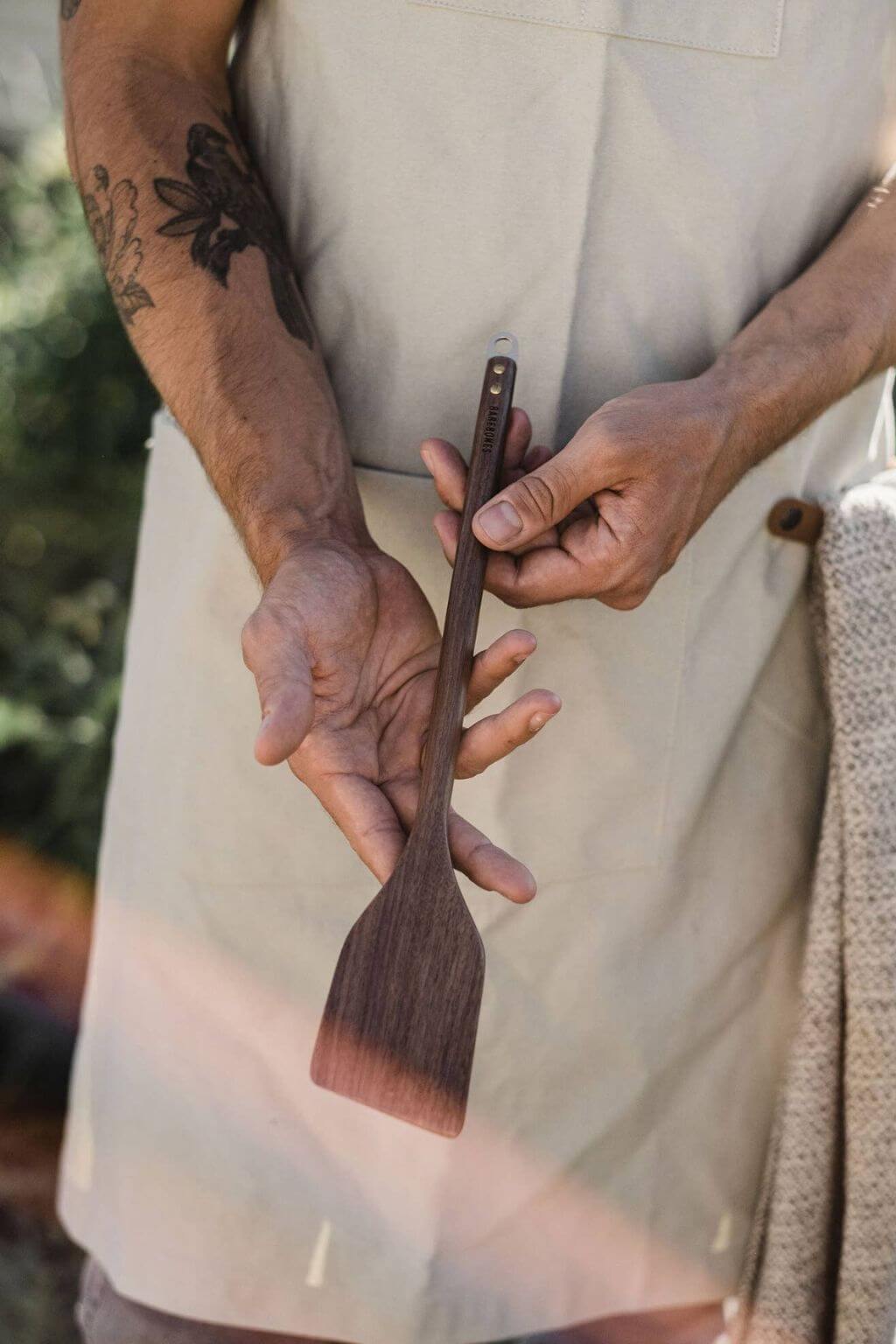 Black walnut wooden spatula with copper accent held in hand