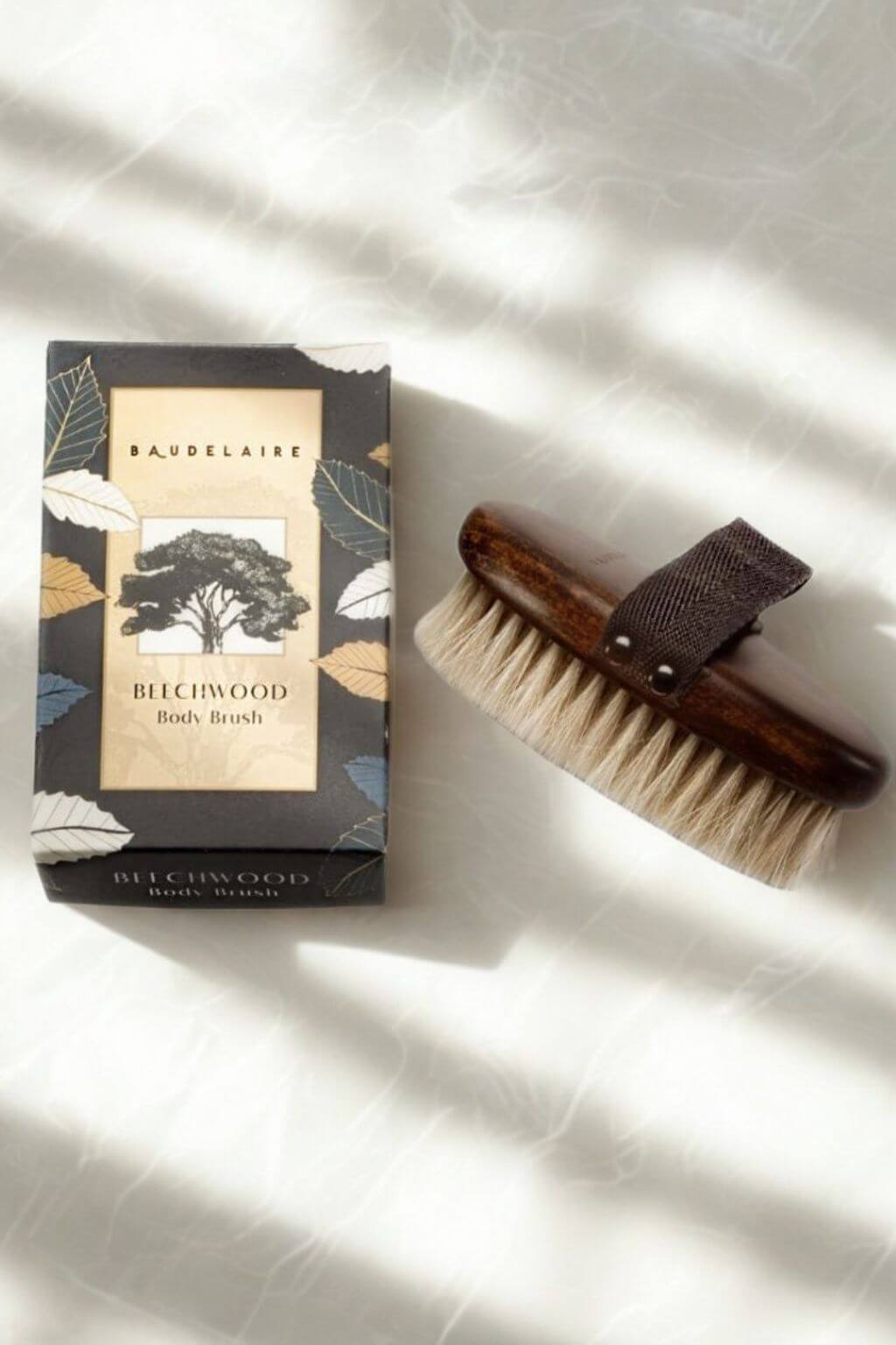 Baudelaire Beechwood Body Brush beside packaging in natural light