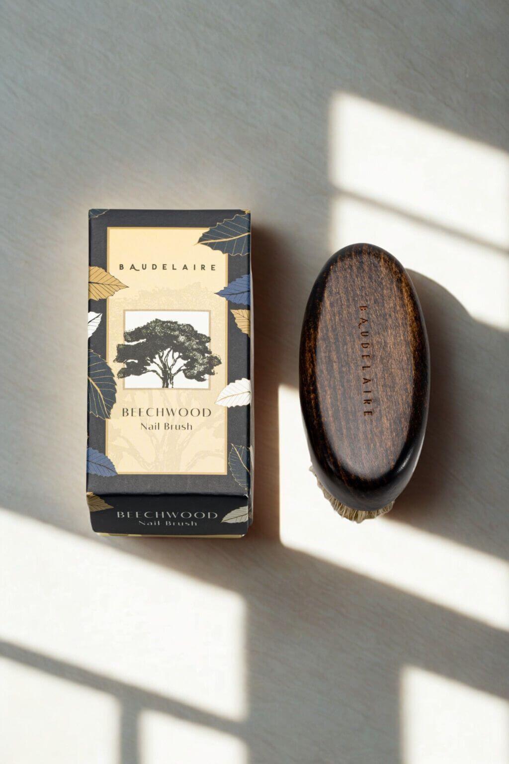 Baudelaire Beechwood Nail Brush beside product box on sunlit surface