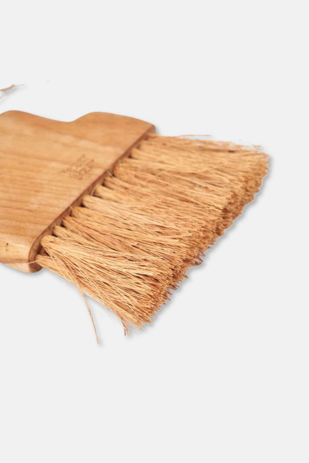 Close-up of natural fiber bristles on teak table brush