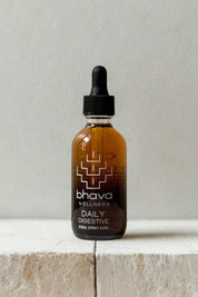 Bhava Wellness Daily Digestive bottle on a light wooden surface with a neutral background
