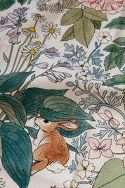 Close-up of tea towel fabric showing rabbit illustration among leaves and flowers