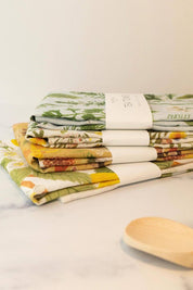 Stack of illustrated linen tea towels by Botanica Paper Co. including Botanist design.