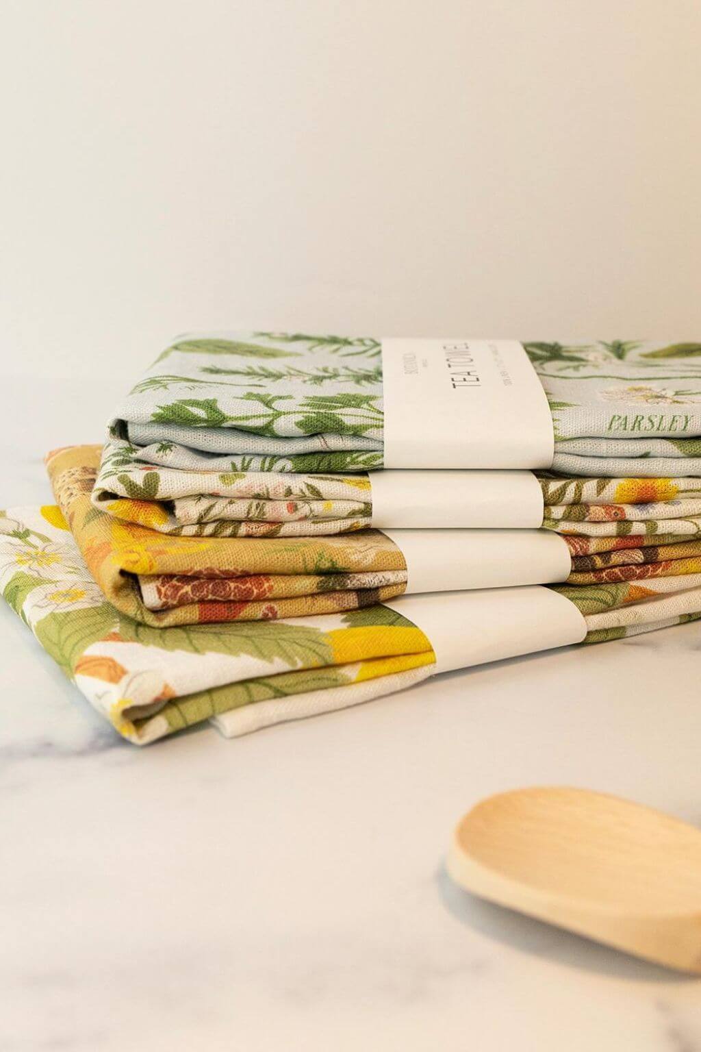 Stack of illustrated linen tea towels by Botanica Paper Co. including Pear Orchard design