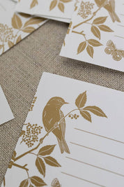 Meadow Gift Labels featuring golden illustrations of birds and wild botanicals on a textured surface.