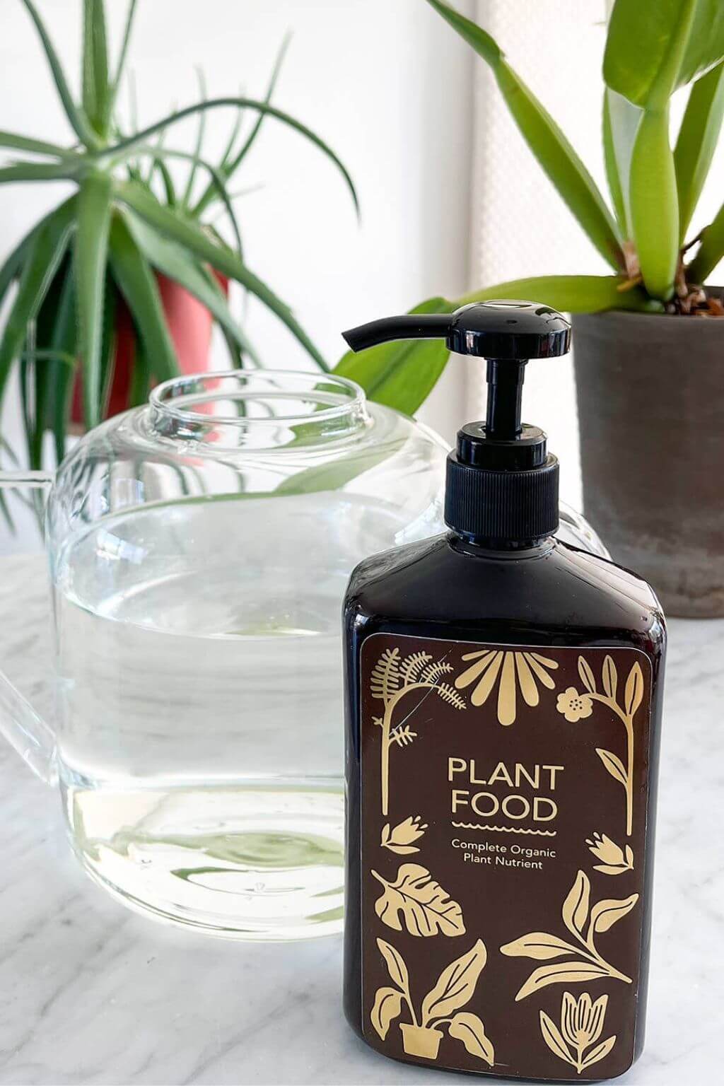 Organic plant food bottle beside houseplants