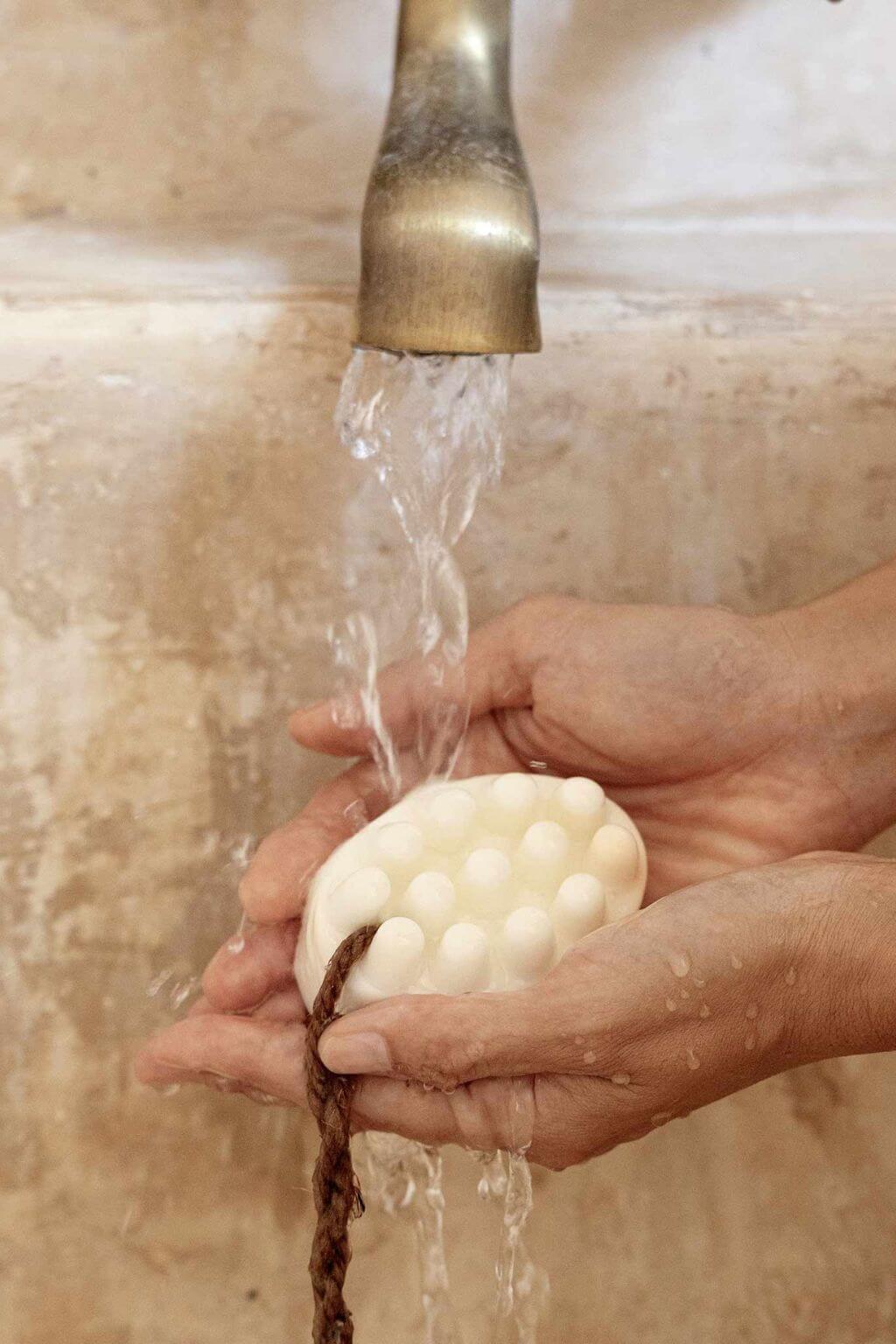 rinsing hinoki shea butter bar soap under water bath ritual