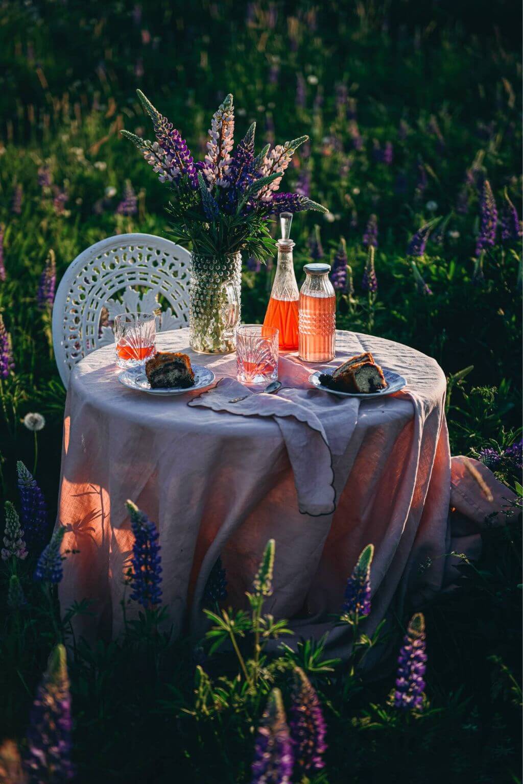 Romantic garden table with candles and summer drinks for Nordic outdoor entertaining