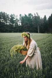 Woman harvesting grain in a summer field inspired by Nordic countryside traditions