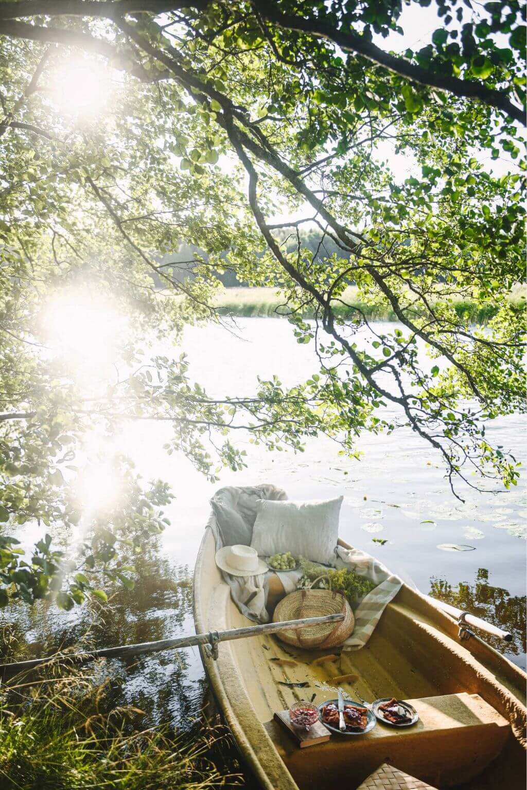 Wooden boat on a lake packed with items for hte prefect Nordic summer picnic