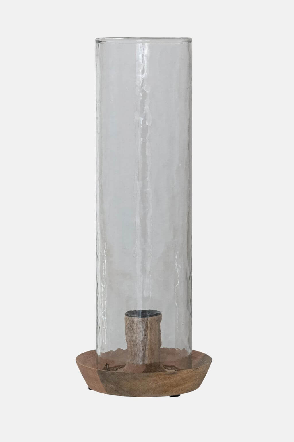 A tall cylindrical clear glass candle holder with a textured finish, sitting on a round natural wood base with a small central candle insert, shown against a light gray background.