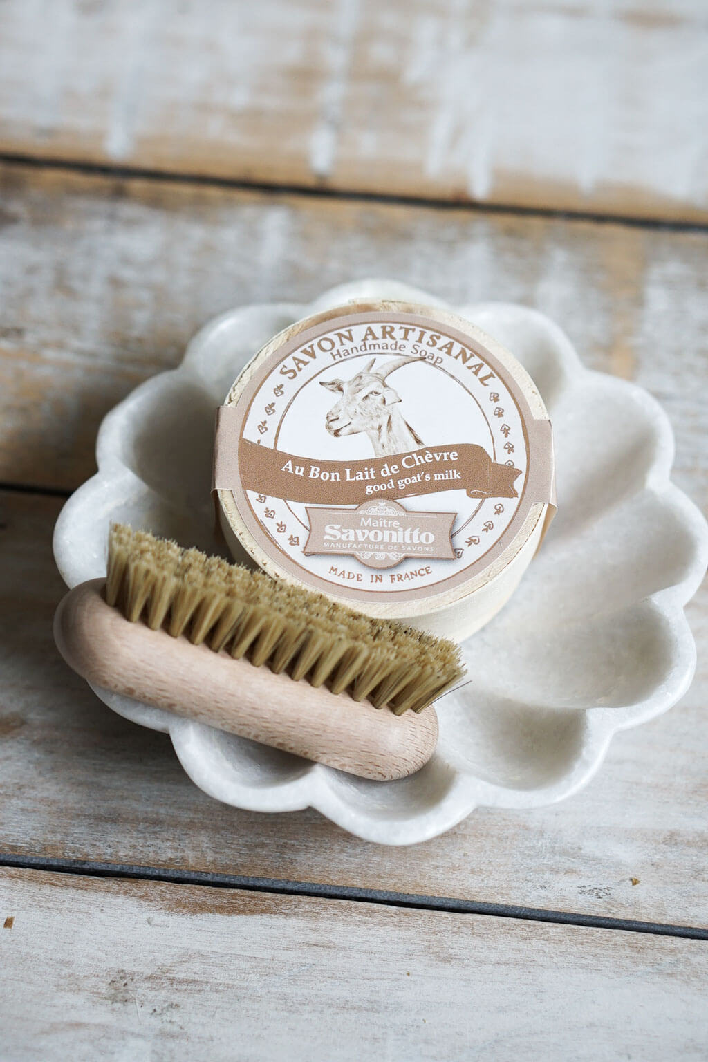 Marble dish styled with goat milk soap and wooden nail brush