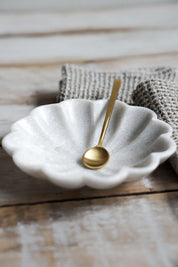 petite brass spoon resting in marble dish kitchen styling