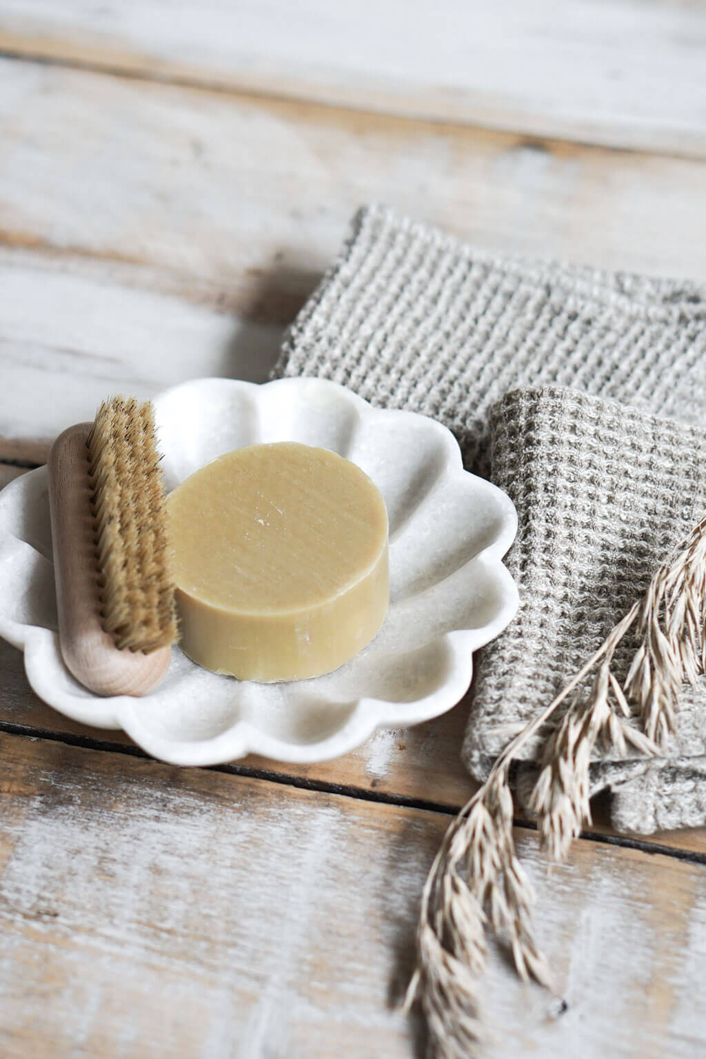 Natural linen waffle dishcloth beside handmade soap and natural brush