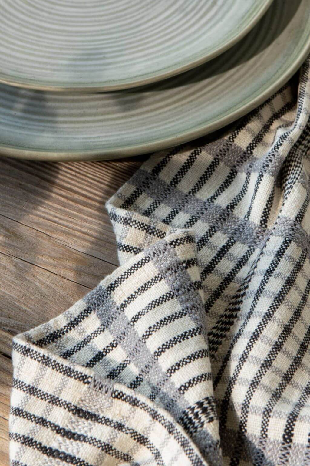 close up pewter check cotton dish towel with ceramic plates