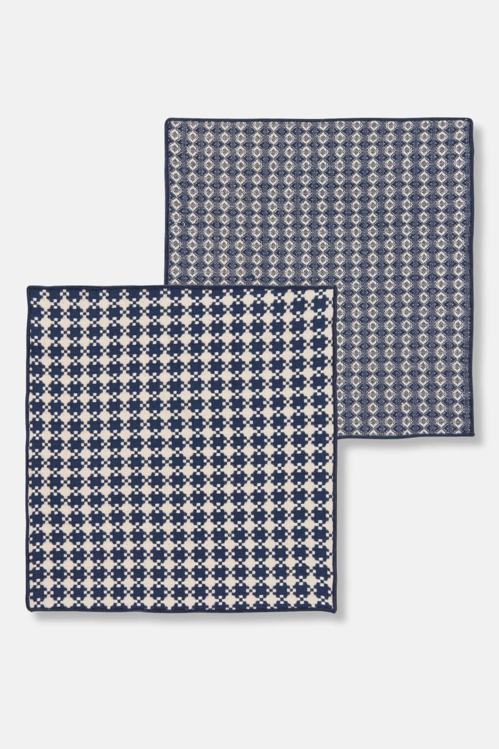 Flat-lay of two patterned woven dishcloths, part of a midnight blue cotton set.