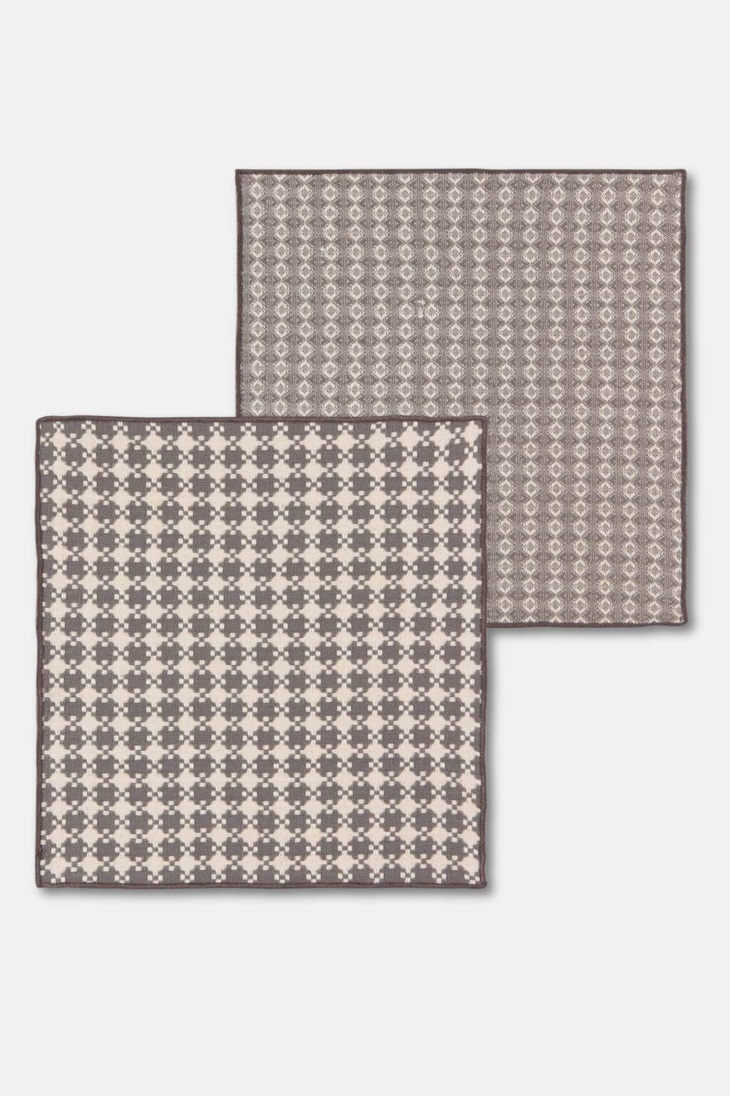 Flat-lay of two patterned woven dishcloths, part of a shadow gray cotton set.