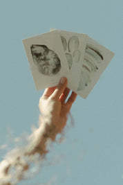 hand holding the depths tarot cards against blue sky