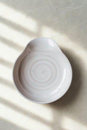 white handmade ceramic spoon rest with subtle spiral glaze texture