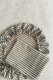 Ticking striped fabric bread bag and dough bowl cover on a light gray background