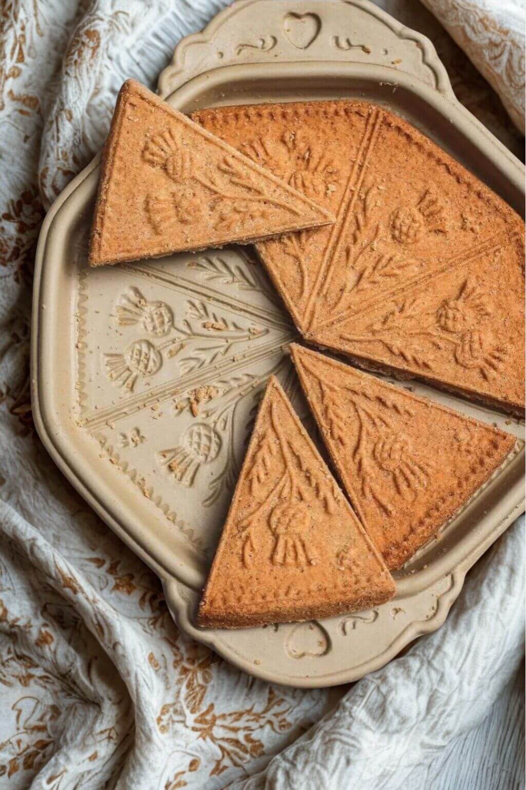 Handcrafted ceramic shortbread pan with triangular shaped shortbread cookies with a thistle design