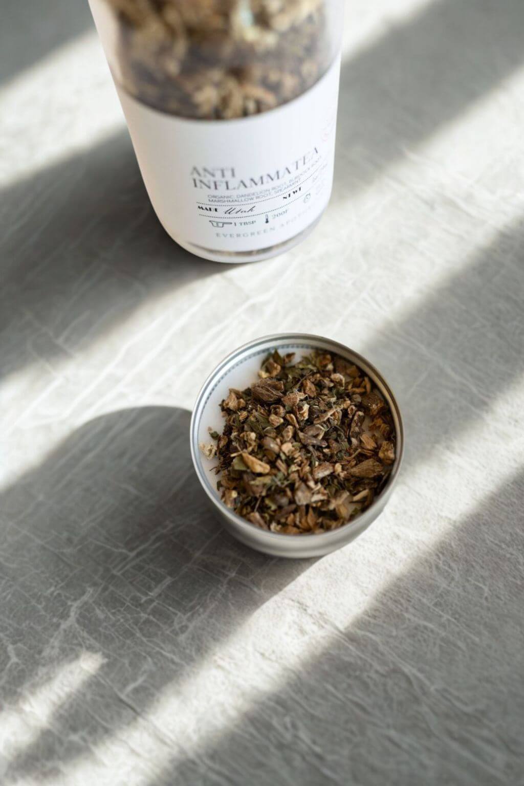 Lid of Anti-Inflammatea jar open, showing loose tea leaves in shallow dish