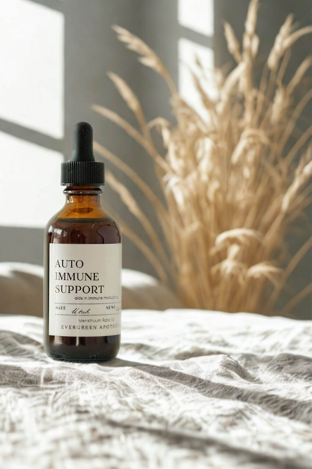 evergreen apothecary autoimmune support herbal tincture with dried grasses and window light